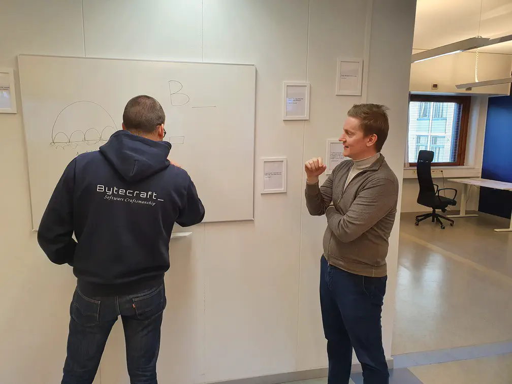 Säpinää whiteboardin ympärillä. Kuvaustilanteessa ei vahingoitettu konsultteja